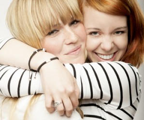 red and blond haired girls laughing and hug